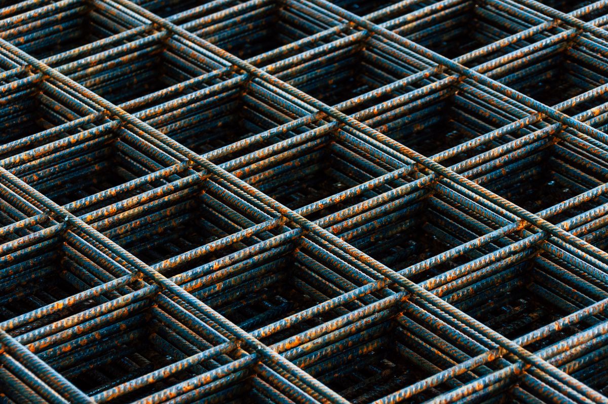 Detailed view of a rusty rebar grid used in construction, illustrating the same reinforcement principle behind a snake plant leaf's fiber-and-turgor structure