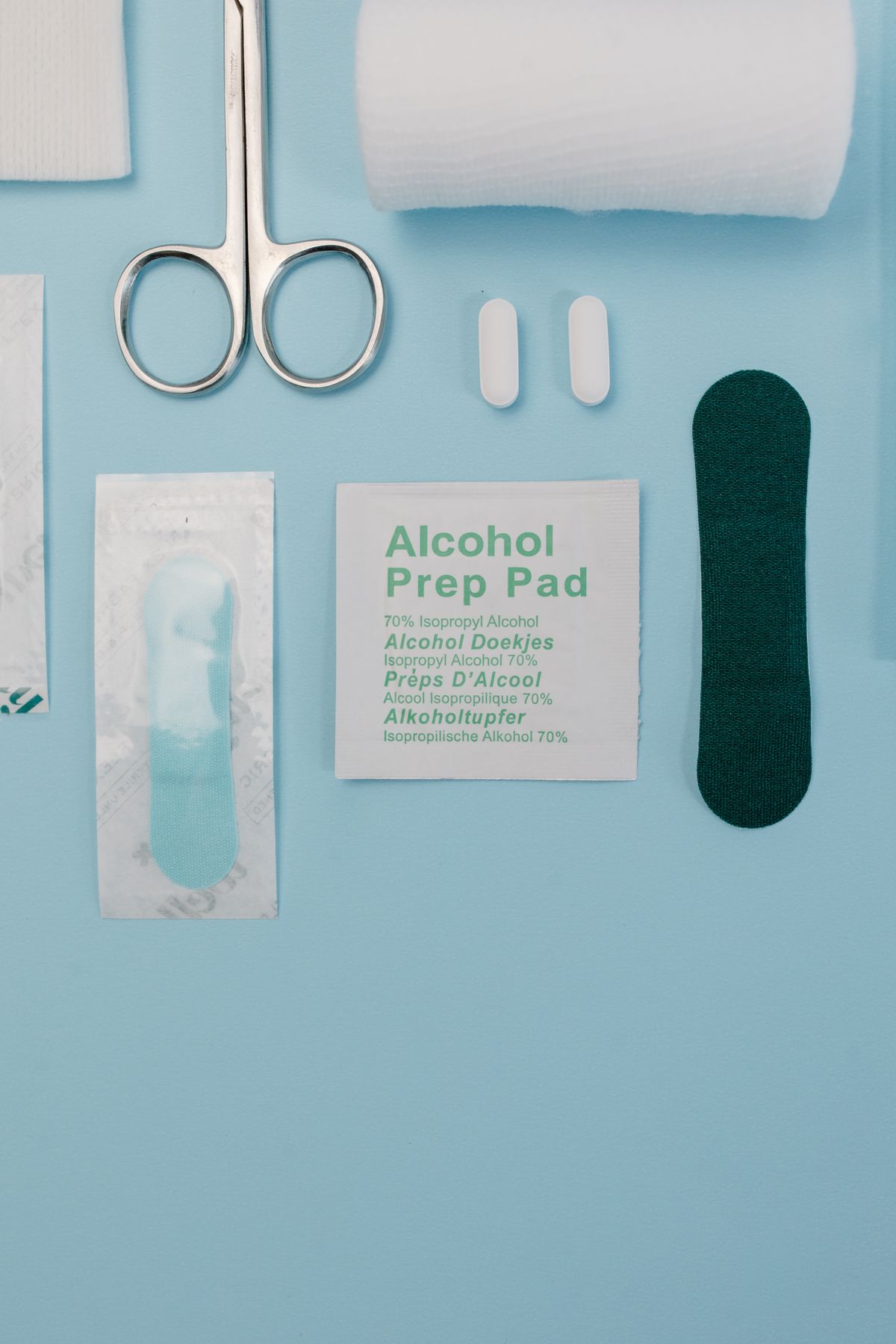 Top view of medical supplies including gauze, scissors, and an alcohol prep pad