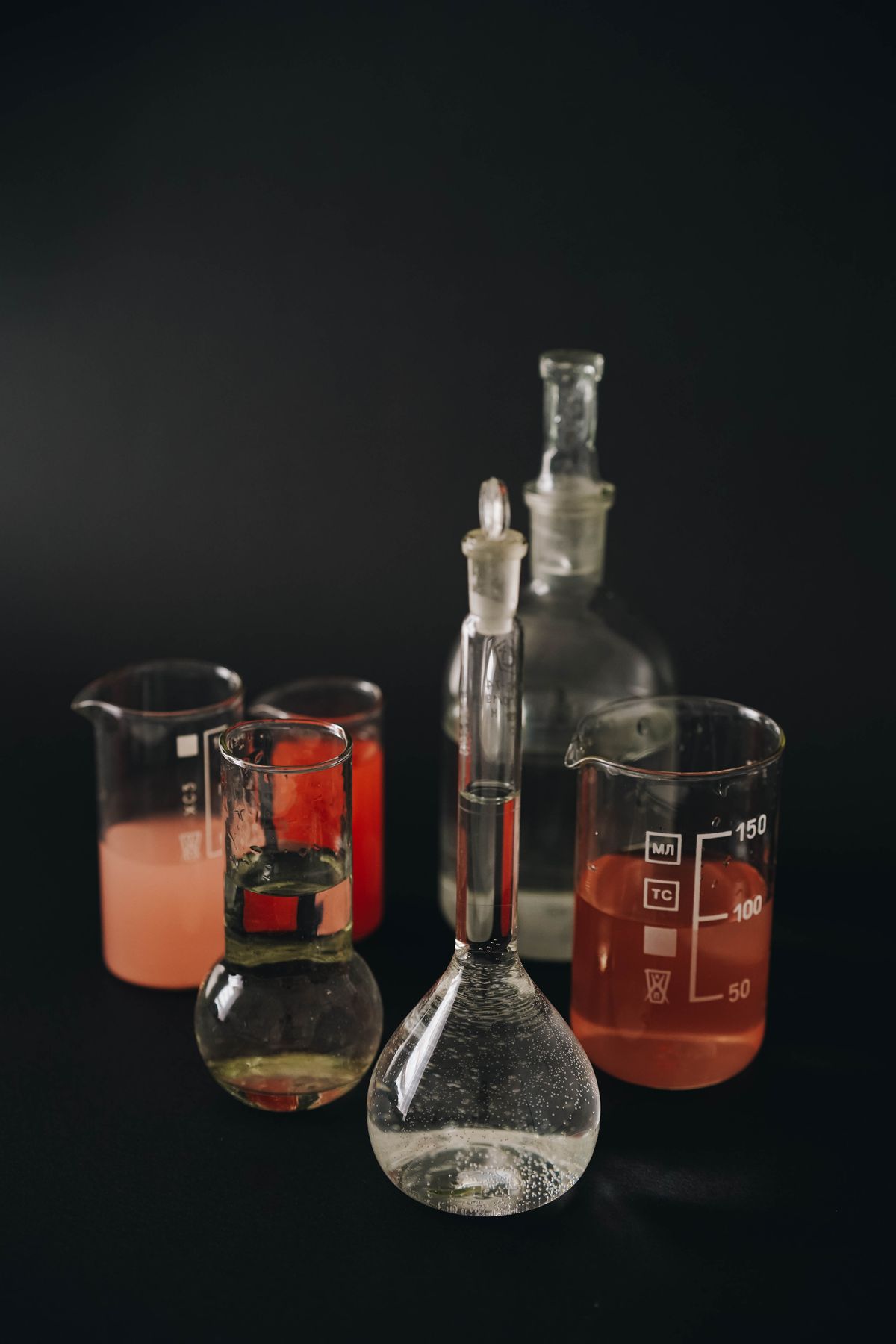 Laboratory glassware with colored chemical liquids, illustrating the kind of chemical treatment process used in alkali fibre treatment